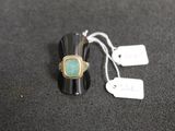 a ring with a green stone on it and a price tag