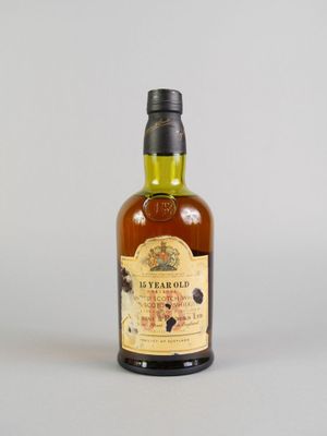 gros plan d'une bouteille de whisky sur une surface blanche
