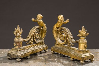 two gold statues on a marble table with a black background