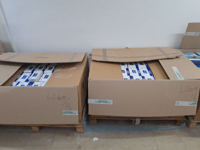 de nombreux cartons posés sur des palettes dans la pièce