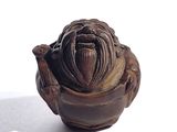un petit vase marron orné d'un visage