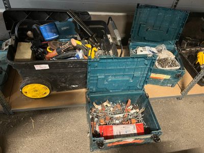 de nombreux outils dans une boîte bleue posée par terre