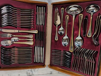 de nombreuses cuillères et fourchettes dans une boîte posée sur la table