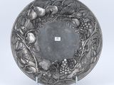 an antique silver plate with fruit and flowers on it