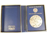a blue box with a silver medal inside of it