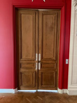 deux portes en bois dans une pièce aux murs rouges