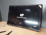 un téléviseur posé sur une table, avec une paire de ciseaux à côté