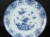 blue and white plate with birds and flowers on it