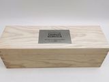 La boîte est en bois et comporte une plaque métallique.