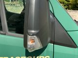 a green truck with a side view mirror on the side of it