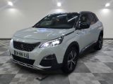 la voiture blanche est garée sur un sol en damier dans le garage