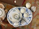 a table with a plate, cups, and saucers on it