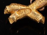 a close up of a gold object on a black surface