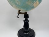 a blue and green globe on a black stand