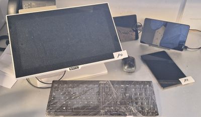 un écran d'ordinateur, un clavier, une souris et d'autres appareils électroniques posés sur un bureau