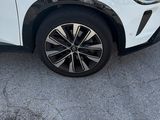 the white car is parked on the side of the road in the parking lot
