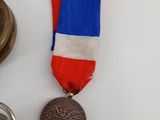 a medal with a red, white, and blue ribbon on it
