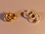 deux paires de boucles d'oreilles en or posées sur un fond blanc