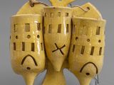 three yellow vases sitting on a metal stand with faces painted on them