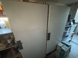 a white refrigerator in a room with a lot of boxes on the floor