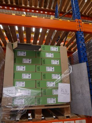 une grande caisse remplie de cartons, posée sur une palette dans un entrepôt