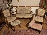 quatre chaises et un canapé dans une pièce recouverte d'un tapis