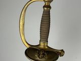a close up of a sword with a gold handle on a white background