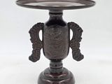 un vase en bronze posé sur un socle et orné d'un oiseau