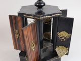 a small black and gold box with a door open