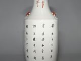 a white vase with asian writing on it sitting on a table