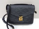 un sac à bandoulière Louis Vuitton noir avec des finitions dorées