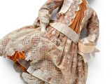 une poupée ancienne représentant une femme en robe et bottes