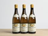 trois bouteilles de vin posées sur une table en bois