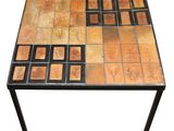 a table made out of tiles with a black metal frame