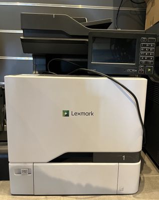 the printer is sitting on the counter in front of the microwave