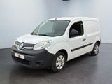 La camionnette blanche est garée dans une grande pièce au sol noir.