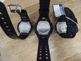 three watches sitting on top of a wooden table next to each other
