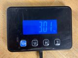 a digital clock on a table with a charger
