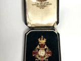 une image représentant une médaille dans un écrin posé sur une surface blanche