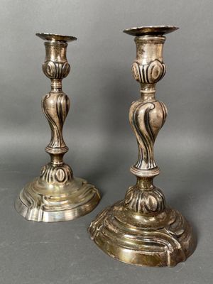 pair of antique brass candlesticks on a grey background