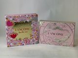two small boxes of perfume sitting next to each other on a table
