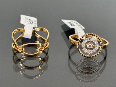 two gold and silver rings with diamonds on a black surface