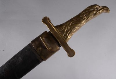 un gros plan d'un couteau orné d'une tête d'aigle en or