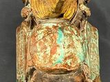 a statue of a bird sitting on top of a bell