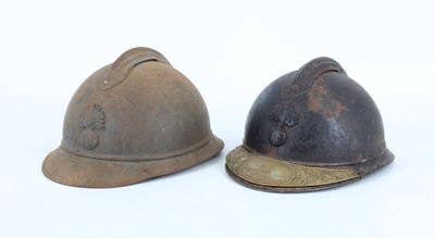 two old fire helmets are sitting on a white surface