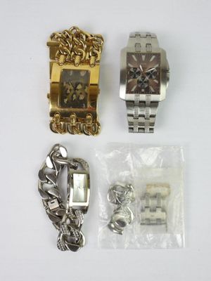 two watches and a bracelet are sitting next to each other