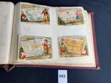an open book with four stamps on it sitting on top of a table