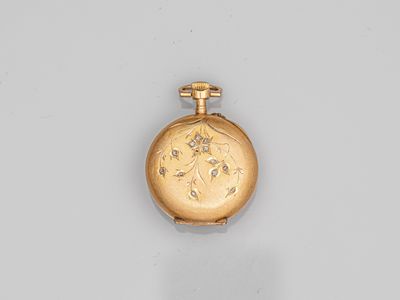 a close up of a gold pocket watch on a white surface