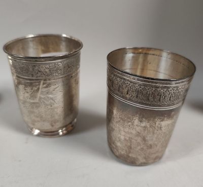 deux tasses en argent posées l'une à côté de l'autre sur une table