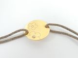 bracelet with a gold disc on a string with a diamond clasp